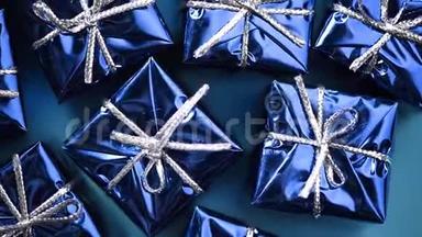 蓝色背景上的蓝色礼盒。 圣诞节和新年的旋转背景。 现在，惊喜的概念